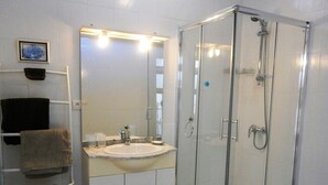 A bathroom with a glass-enclosed shower, a sink, and a towel rack. - Spacious loft apartment in charming Saint-Chinian (saint-Chinian)