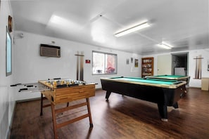 A room with a foosball table, a pool table, and a bookshelf. - Pet Friendly Cabin in Gatlinburg (Gatlinburg)