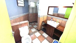Un bagno con servizi igienici, lavandino e specchio.