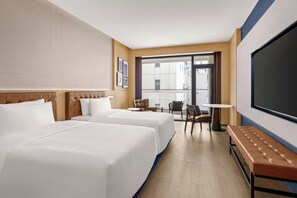A hotel room with two beds, a seating area with a table and chairs, a large TV screen, and a view of the outside. - Four Points by Sheraton Guilin Central (Guilin)