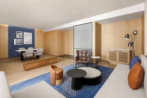Una sala de estar moderna con un sofá, sillones, una mesa de centro, un comedor con sillas y una cocina con un armario.