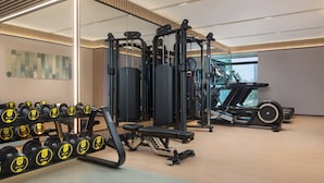 A gym with various exercise equipment, including dumbbells and a treadmill. - Holiday Inn Shanghai Necc by IHG (Shanghai)
