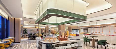 A modern hotel lobby with a central bar area, seating arrangements, and a patterned floor.