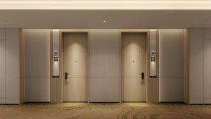 A row of four identical doors with a digital display above each, set in a modern interior with a carpeted floor. - Holiday Inn Shanghai Necc by IHG (Shanghai)
