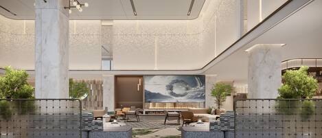 A spacious lobby with a high ceiling, marble columns, and a large wall-mounted artwork.