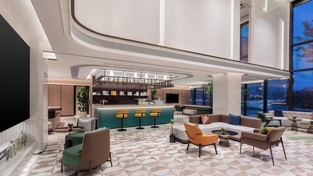 A modern lobby with a bar area, seating, and a large TV screen. - Holiday Inn Shanghai Necc by IHG (Shanghai)