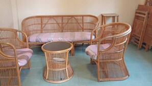 Una habitación con sofá, dos sillones, una mesita y un cuadro en la pared.