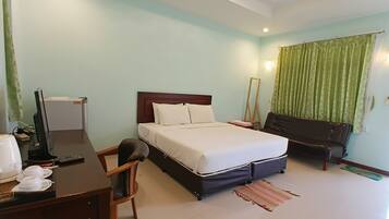 Una habitación de hotel con cama, escritorio, silla y espejo.