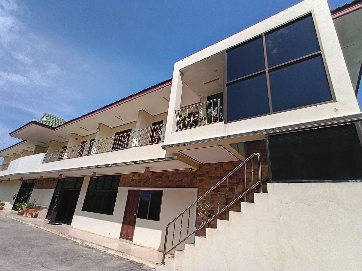 Un edificio de varios pisos con escaleras, balcones y ventanas grandes.