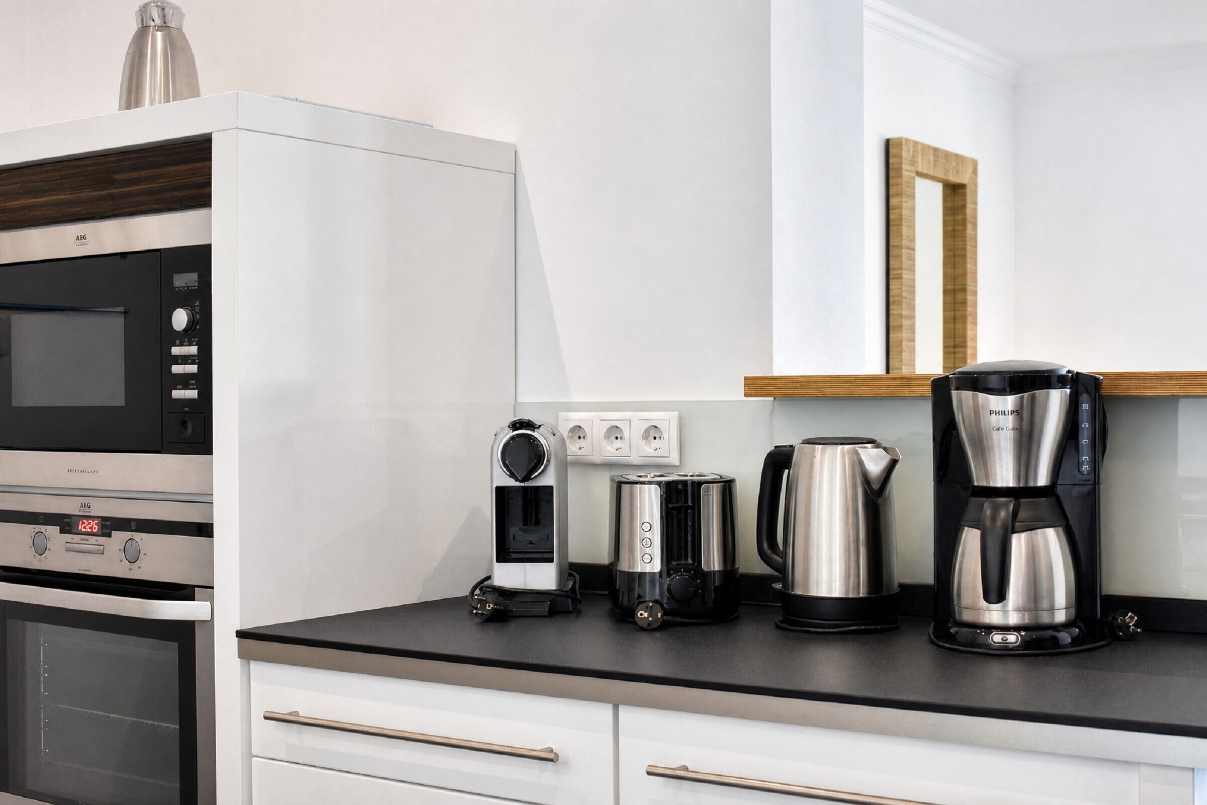 A kitchenette with a built-in oven, microwave, toaster, and coffee maker.