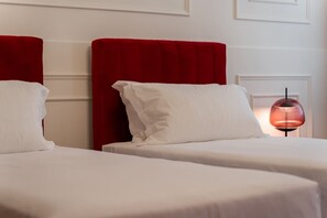 A hotel room with two beds, each with a red headboard and white bedding. - Venetian Velvet (Venice)