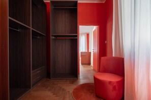 A hallway with a wardrobe, a red chair, and a door leading to another room. - Venetian Velvet (Venice)