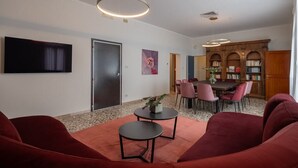 Uma sala de estar moderna com um sofá, uma mesa de centro e uma área de jantar com cadeiras e uma mesa.
