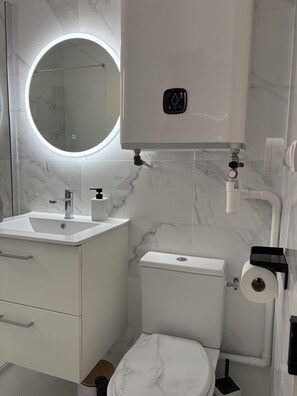 Een douche, handdoeken, zeep, toiletpapier