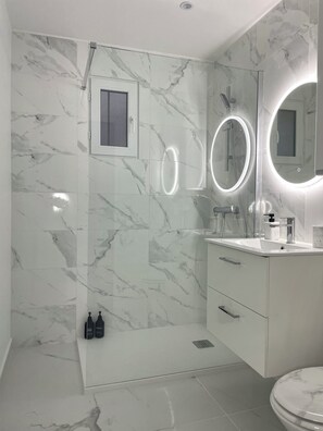Een douche, handdoeken, zeep, toiletpapier