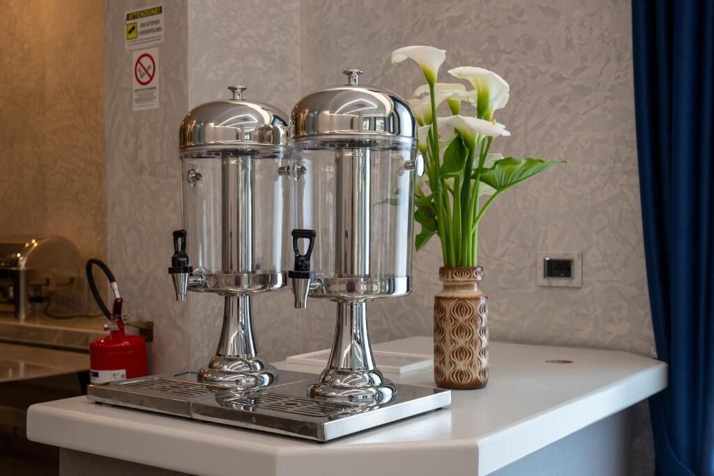 Un distributeur d’eau, une extincteur et un vase avec des fleurs, le tout posé sur un comptoir.