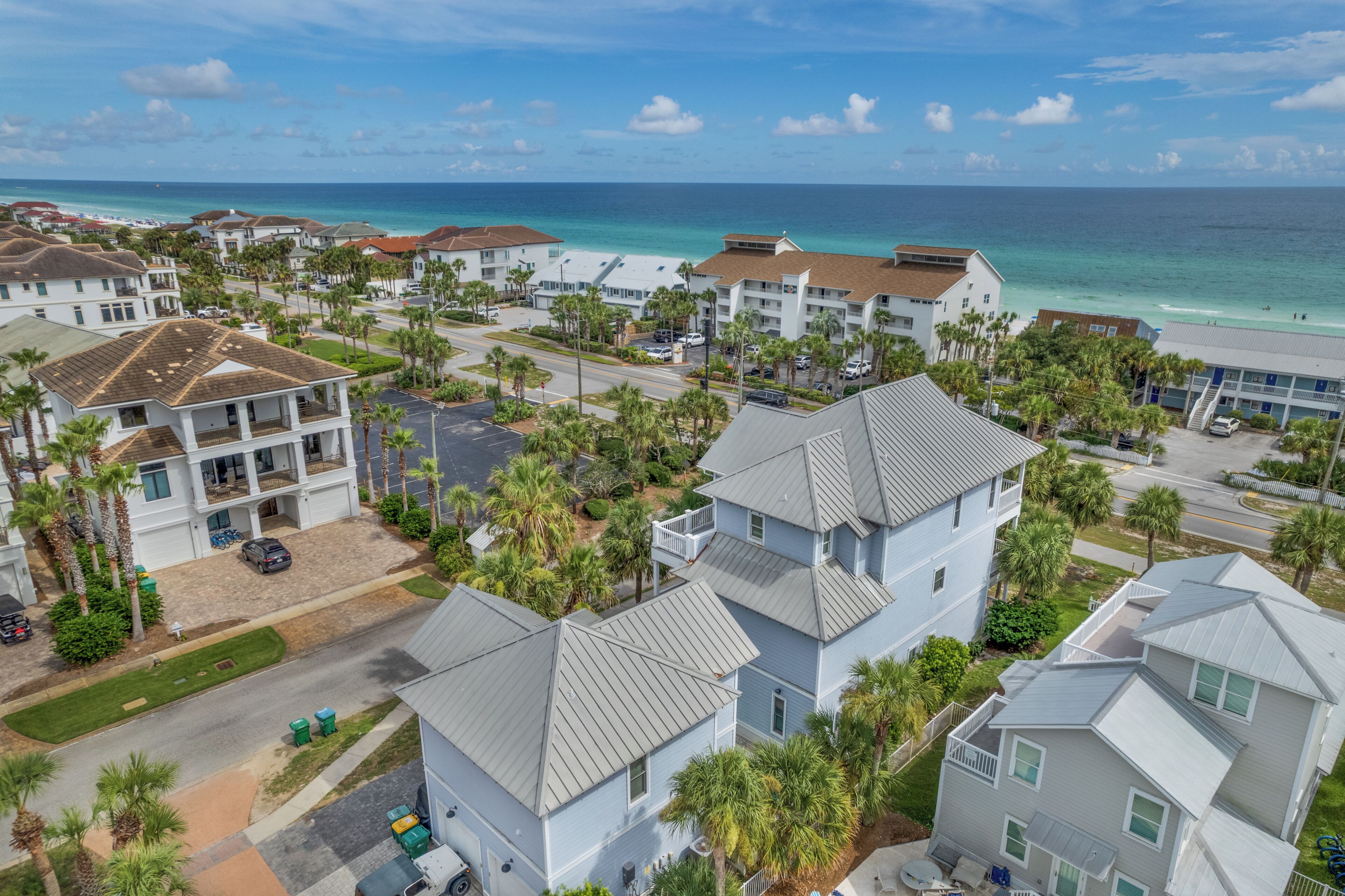 A coastal residential area with multiple two-story houses, a clear view of the ocean, and a well-maintained street.