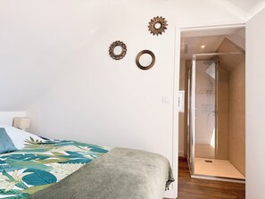 A bedroom with a bed, a shower, and wall decorations. - The 37th - "The 21st Plate" Collection (Bayeux)