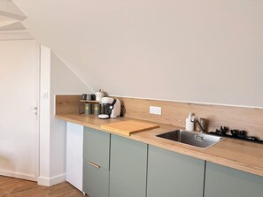 A kitchen with a wooden countertop, a coffee maker, and a sink. - The 37th - "The 21st Plate" Collection (Bayeux)