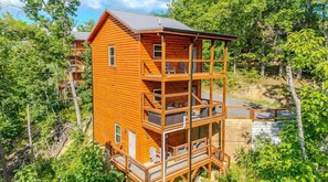 A multi-story wooden cabin with balconies, surrounded by trees. - Smoky Ridge Retreat | 2 Cabins, Views & Games (Sevierville)