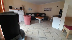 A living room with a sofa, coffee table, and a television. - Gemutliches Ferienhaus mit Terrasse Nahe dem Muritzsee in Rechlin (Rechlin)