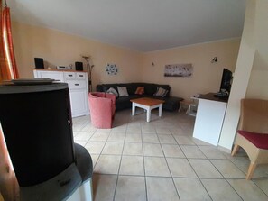 A living room with a sofa, coffee table, and a television. - Gemutliches Ferienhaus mit Terrasse Nahe dem Muritzsee in Rechlin (Rechlin)