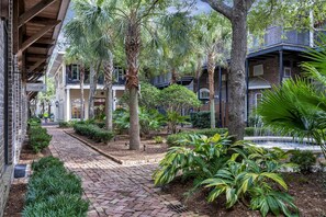 A courtyard with a brick pathway, palm trees, and a fountain. - 2 Bedroom condo at Fisherman’s Wharf inside Sandestin Golf and Beach Resort (Miramar Beach)