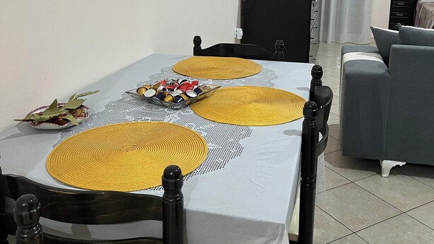 Un coin repas avec une table dressée, agrémentée de sets de table, de chaises et d’une petite plante décorative.