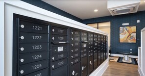 A row of black mailboxes with numbers 1221 to 1236, a U.S. Mail label, and a small table with a glass top in the background. - Parkview Greer 2BR Retreat (Greer)