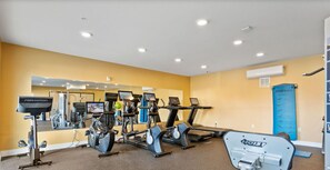 A gym with various exercise equipment, including treadmills, stationary bikes, and free weights. - Parkview Greer 2BR Getaway (Greer)