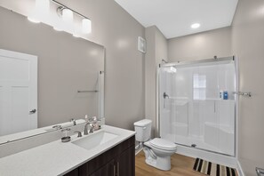 A modern bathroom with a shower, toilet, and sink. - Homey 2BR with Great Space (Greer)