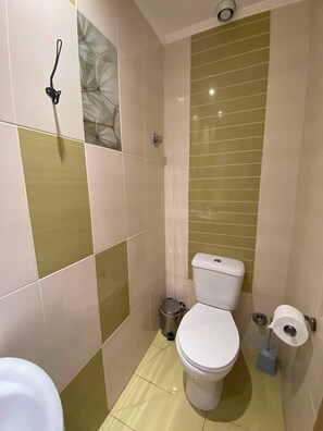 A bathroom with a toilet, bidet, and a trash bin. - Corinth Beach Apartment (Korinthos)