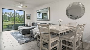 A dining area with a table, chairs, a sofa, and a large mirror. - New To Market- All New Furnishings- Lakewood National Golf Condo with Resort Amenities (Bradenton)