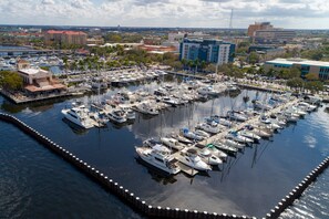 A marina with numerous boats docked, surrounded by buildings and palm trees. - New To Market- All New Furnishings- Lakewood National Golf Condo with Resort Amenities (Bradenton)