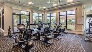 A gym with multiple cardio machines, large windows, and a view of a building outside. - New To Market- All New Furnishings- Lakewood National Golf Condo with Resort Amenities (Bradenton)