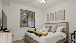 A bedroom with a bed, a television, a window with blinds, and two wall-mounted artworks. - New To Market- All New Furnishings- Lakewood National Golf Condo with Resort Amenities (Bradenton)
