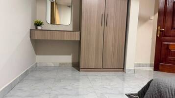 Un dormitorio con armario, mesita de noche y espejo.