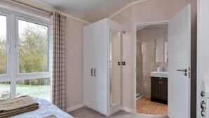 Une chambre avec un lit, une salle de bain avec une douche et une vue sur l’extérieur.