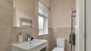 Une salle de bain avec un lavabo, des toilettes et une douche.