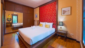 Een hotelkamer met een groot bed, een nachtkastje, een lamp en een spiegel.