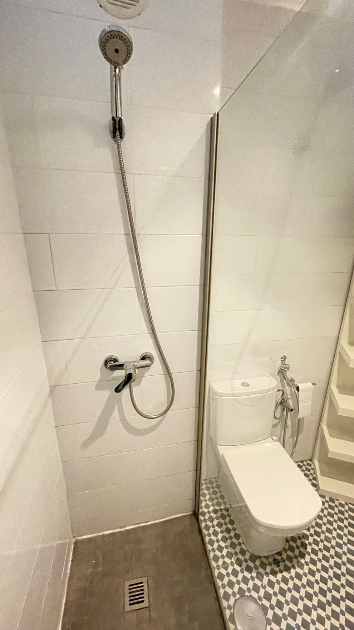 Ein Badezimmer mit Dusche, Toilette und Schachbrettfliesen.