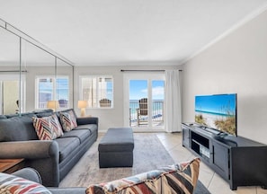 A modern living room with a sofa, ottoman, and a flat-screen TV. - (621) Gulf-Front Condo on 6th Floor, Sleeps 6, Kings, FREE Beach Service (Destin)
