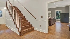 A staircase with wooden steps and white railings, leading to a landing with a door. - Luxury and location in the Heartland (Wauchula)