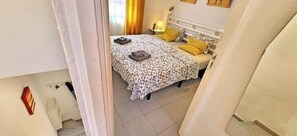 Ein Schlafzimmer mit einem Bett, zwei Nachttischen und einem Beistelltisch.