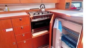 Uma cozinha compacta com armários de madeira, fogão a gás e forno embutido.