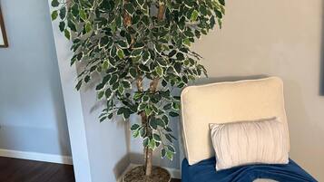 Une pièce avec un lit, une plante en pot et un panier tressé.