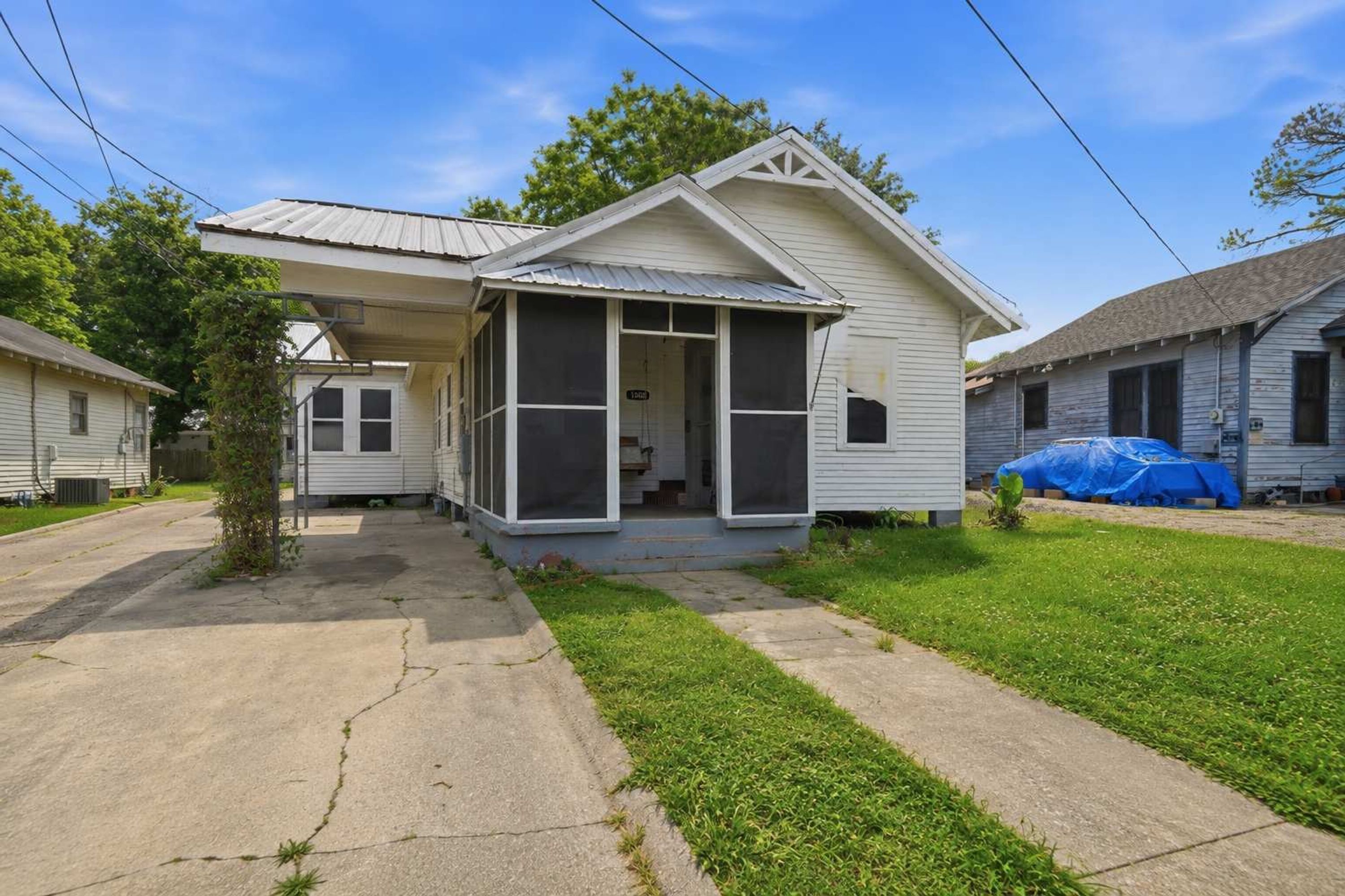 A single-story house with a covered porch, a visible garage door, and a small front yard.