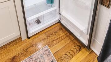 A compact refrigerator with two door compartments, a built-in ice maker, and a water dispenser.