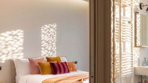 A modern bedroom with a bed, nightstand, and a bathroom visible through an open door. - Casa Bonvicino Citt Studi (Milan)