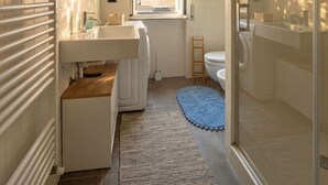A modern bathroom with a glass shower enclosure, a white sink, and a window providing natural light. - Casa Bonvicino Citt Studi (Milan)